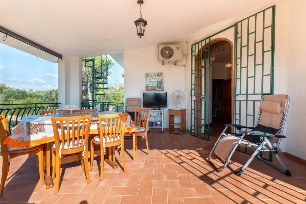 ein Esszimmer mit Tisch und Stühlen auf einem Balkon in der Unterkunft Villa degli Ulivi in San Pietro in Bevagna
