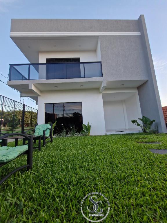 a house with a green lawn in front of it at Residencia SG - Casa Duplex in Encarnación
