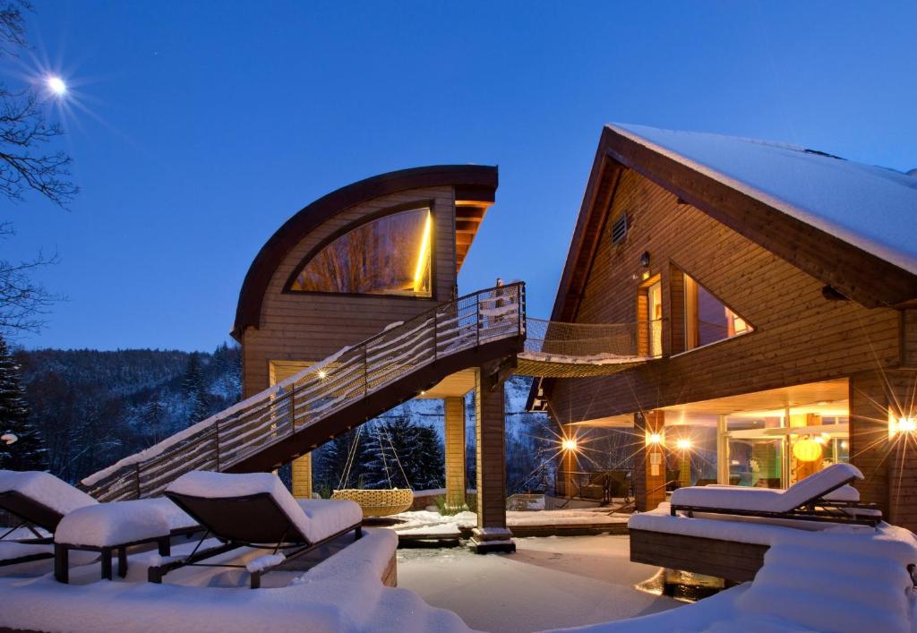 コロワ・ラ・ロシュにあるLA CHENEAUDIÈRE - Hôtel Spa - Relais & Châteaux - Restaurant étoiléの夜の雪家