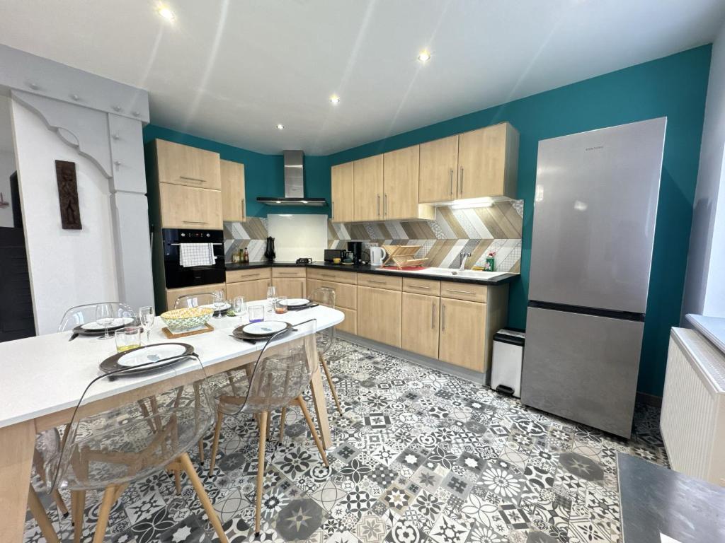 eine Küche mit Tisch und Stühlen und einem Kühlschrank in der Unterkunft La maison d'Audrey - maison au pied du Hahenberg - au calme - parking gratuit in Châtenois