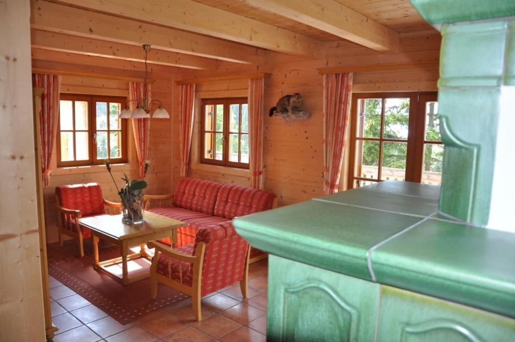 a living room with a couch and a table at Almrausch-Feriendorf Koralpe in Elsenbrunn