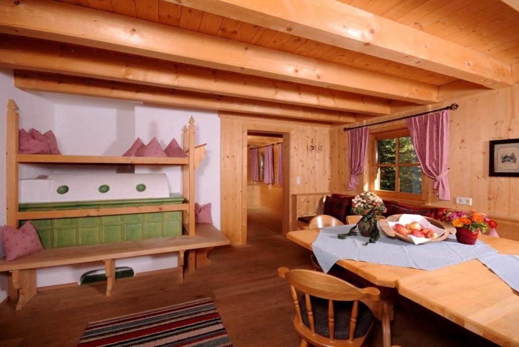 a room with two beds and a table in a cabin at Brandstatt Alm in Grossdornau