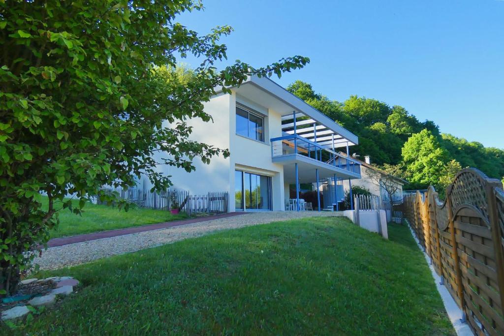 a white house with a fence and a yard at LAC CASA 60' Sixties-style flat with terrace overlooking the lake 300 m in Bilieu