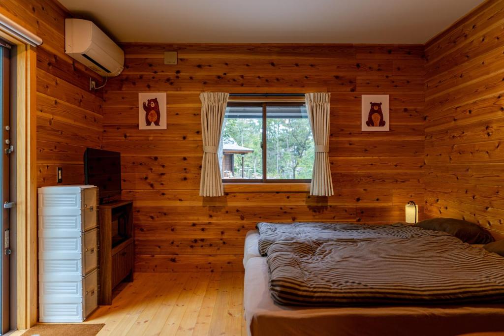 a bedroom with a bed in a wooden room at Azumino Bear's Inn in Azumino