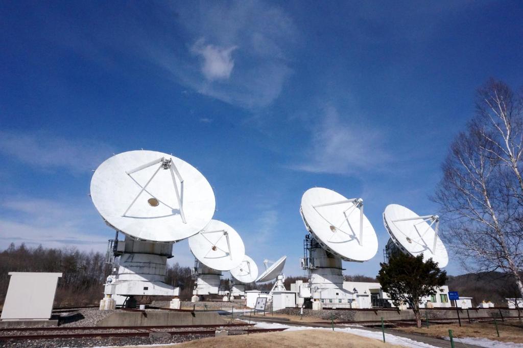 un grupo de antenas parabólicas en la parte superior de un edificio en 八ヶ岳 HOKUTO BASE -Yatsugatake-, en Hokuto
