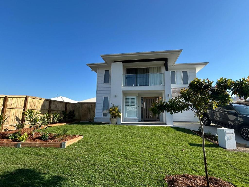 een groot wit huis met een grasveld bij Sugar Shore Retreat in Cudgen