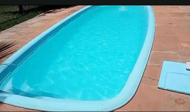 a swimming pool with blue water in a yard at Casa do Bosque in Camaçari