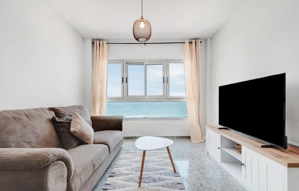 a living room with a couch and a flat screen tv at wonderful tila house, facing the sea in La Garita