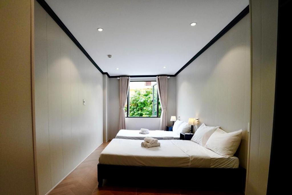 a bedroom with two beds and a large window at HY Local Budget Hotel - 5 mins walk to Hoi An Ancient Town in Hoi An