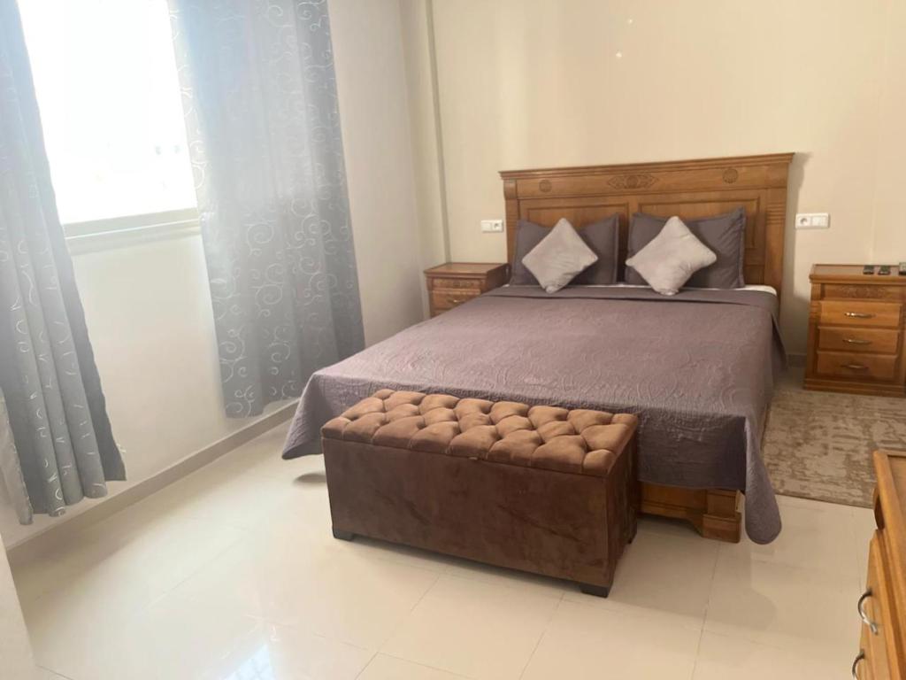 a bedroom with a large bed with a wooden headboard at avenue hassan 2 agadir in Oulad Akkou