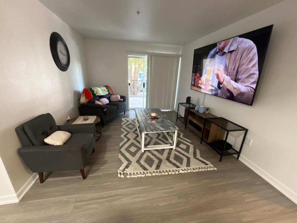 a living room with a couch and a tv on the wall at Very spacious 1Bed 1Bath Unit in Saint-Louis
