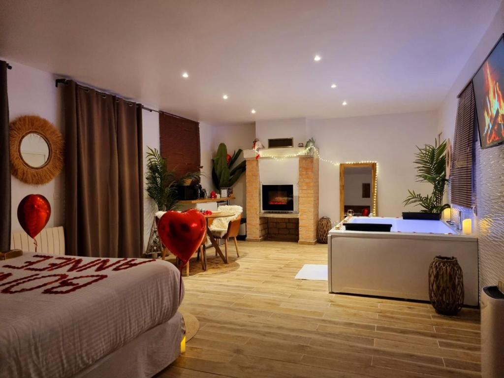 サン・プリにあるSuite de charme jacuzzi et jardin privé 20 min de Paris et Stade de Franceのベッドとリビングルームのある寝室