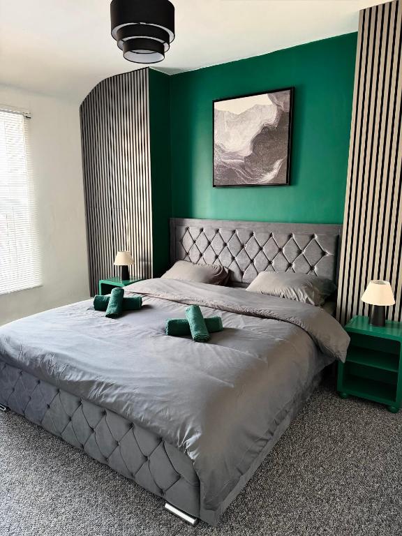 a bedroom with a large bed with green walls at D&D Emerald House Anfield in Liverpool