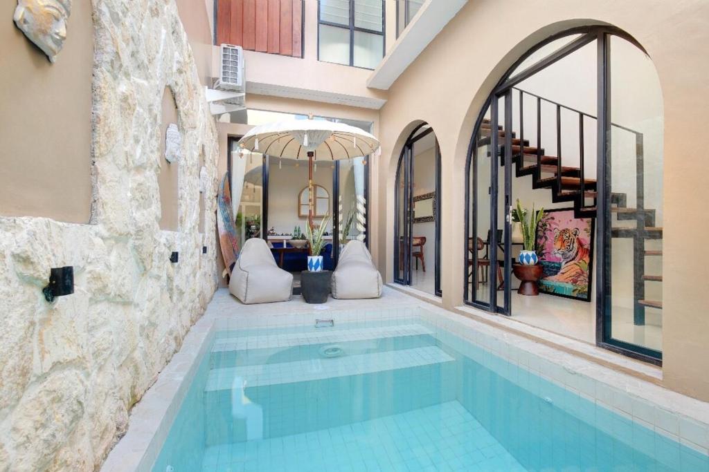 a swimming pool in a building with a house at Luxury 1BR Uluwatu Villa Private Pool & Wi-Fi in Ungasan