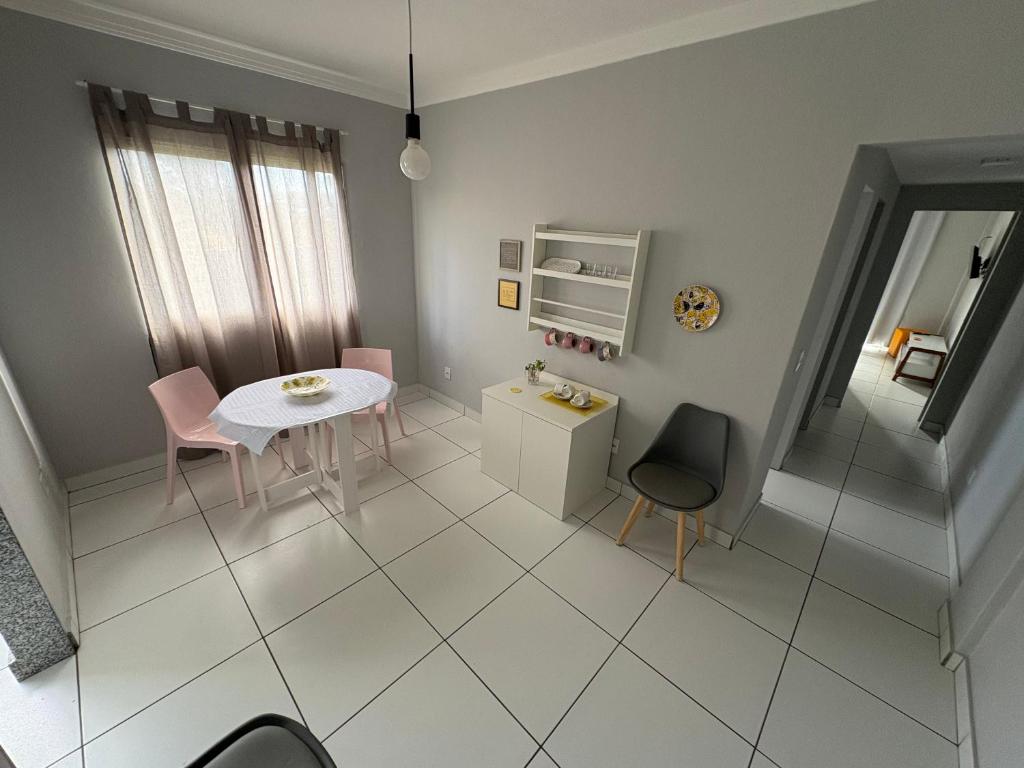 Habitación blanca con mesa, sillas y escalera en Bertholi Beira-Mar, en Serra