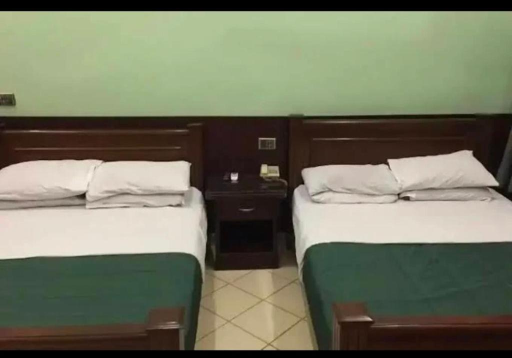 ラホールにあるHotel Indusの部屋に並んで置かれた2つのベッド