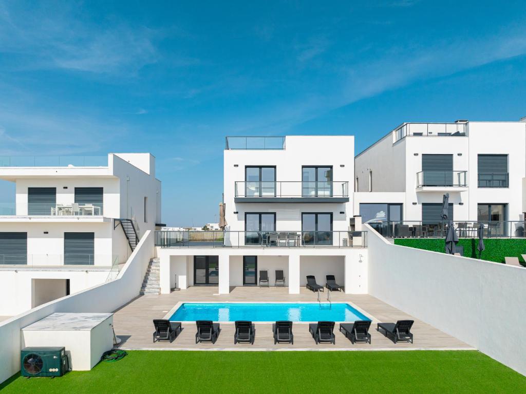 Una vista exterior de una casa con piscina. en Villa Lotus Peralta with sea view, en Lourinhã