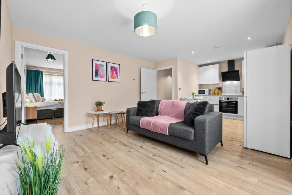 a living room with a couch and a kitchen at Stylish & Spacious 3BR 3Bath with Private Parking, WiFi, Smart TVs in Spon End