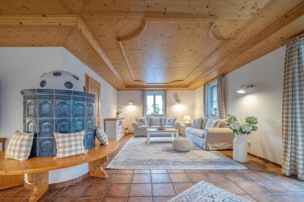 a large living room with a wooden ceiling at Landhaus Königssee in Schönau am Königssee