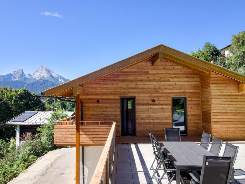 une maison en bois avec une table et des chaises sur une terrasse dans l'établissement Chalet Wachterfeld, à Berchtesgaden