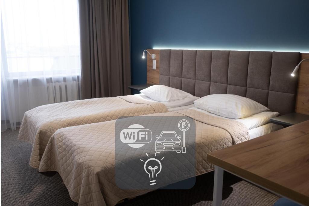 a hotel room with a bed with a sign on it at Hotel Halychyna in Ternopilʼ