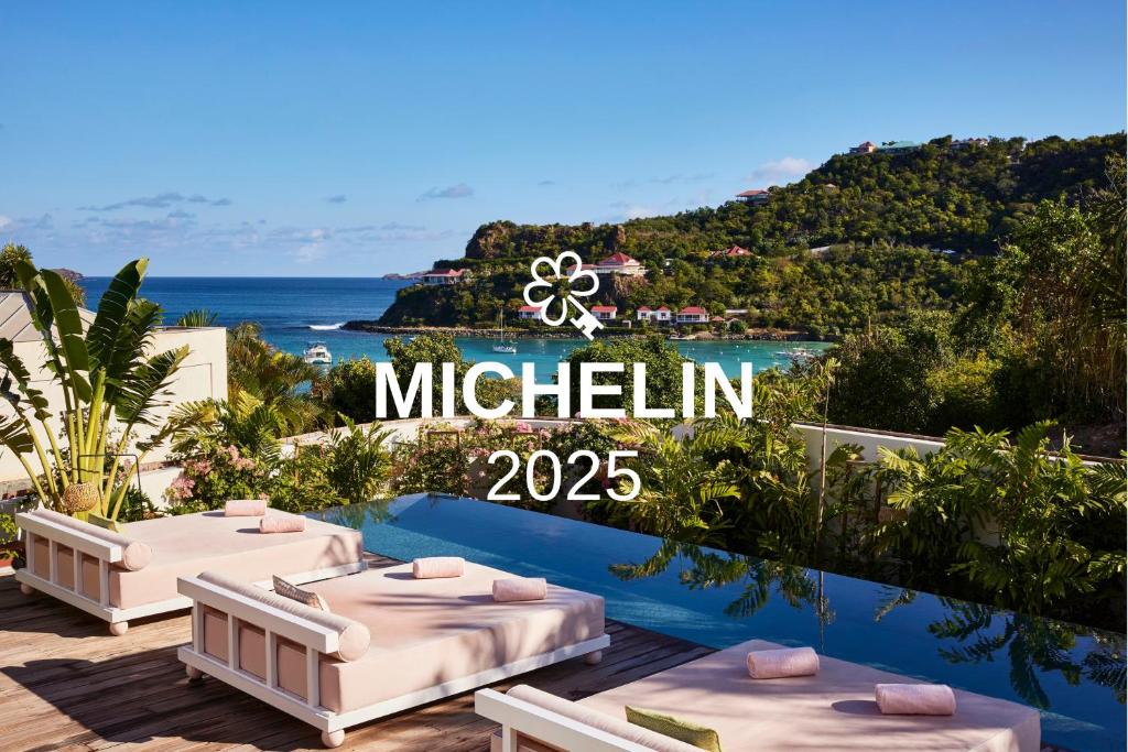 een bord met de tekst mitzlin op een balkon met bedden bij Tropical Hotel St Barth in Gustavia