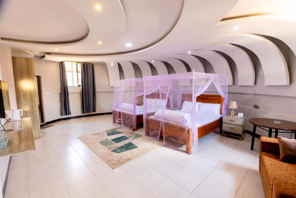 a living room with a bed and a ceiling at Jade Inn in Arusha