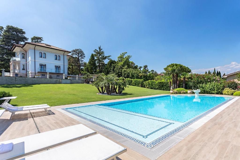 a large swimming pool in front of a house at Villa Angela - Italian Homing in Desenzano del Garda