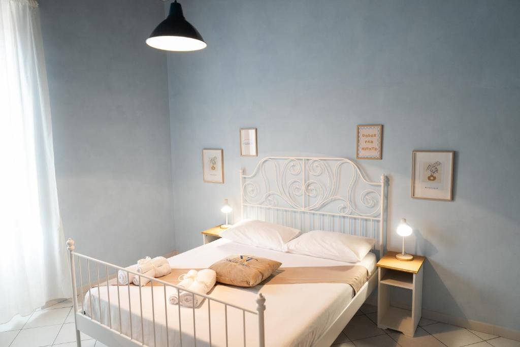 een slaapkamer met een wit bed en een blauwe muur bij Napolitano Rooms - Salerno Town in Salerno