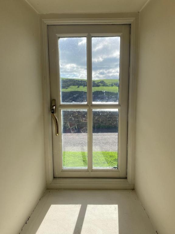 - une fenêtre dans une chambre avec vue sur l'eau dans l'établissement Seaside Cottage Kinsale, à Feevaghmore