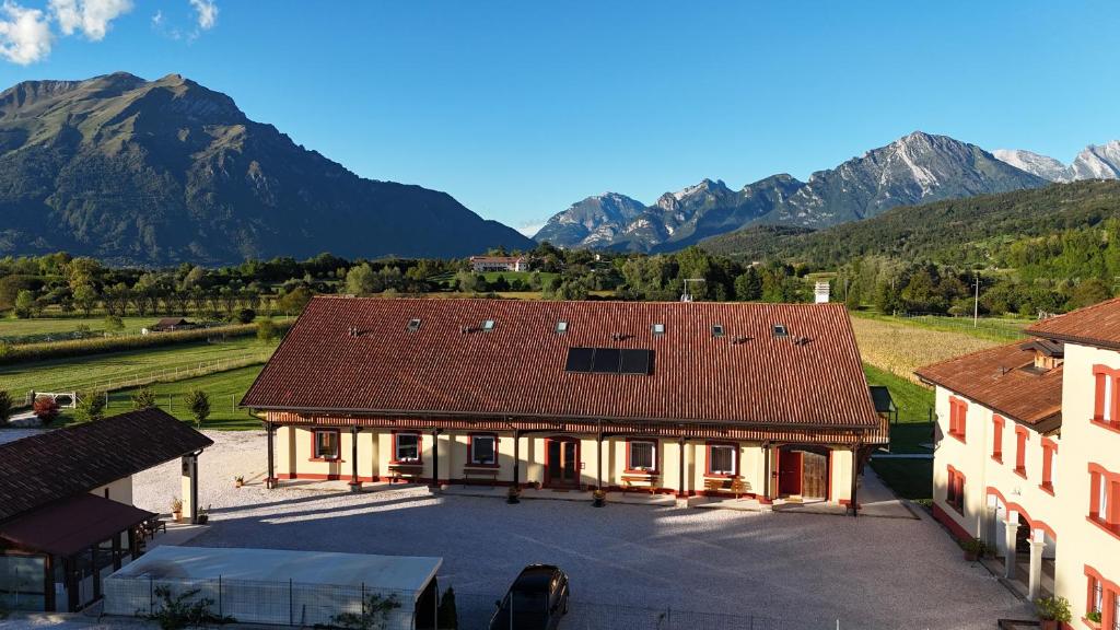an aerial view of a building with mountains in the background at AGRITURISMO MODOLO Belluno Dolomiti in Belluno