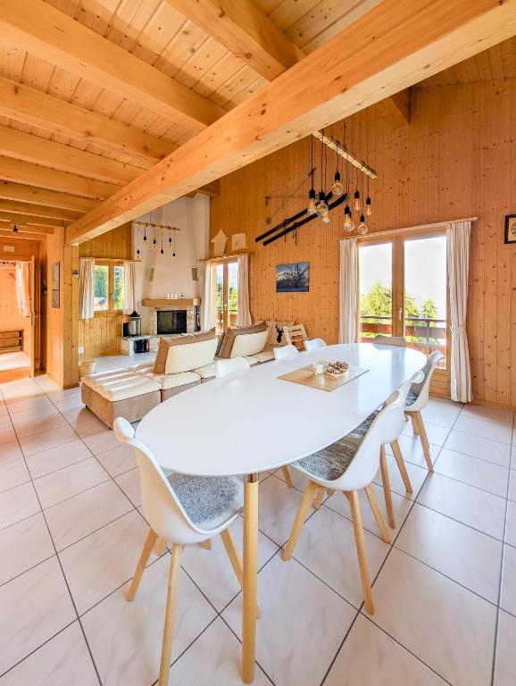 Un comedor con una mesa y sillas blancas. en Grand chalet familial et convivial à La Tzoumaz, en La Tzoumaz