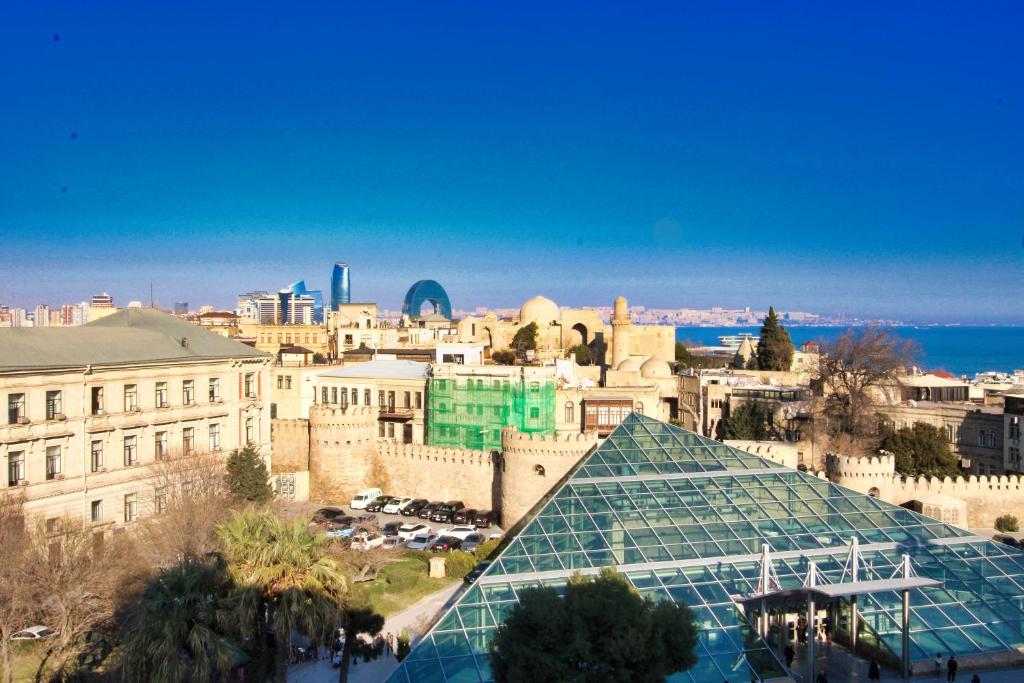 vistas a una ciudad con un edificio de cristal en The Liman Hotel Baku, en Baku