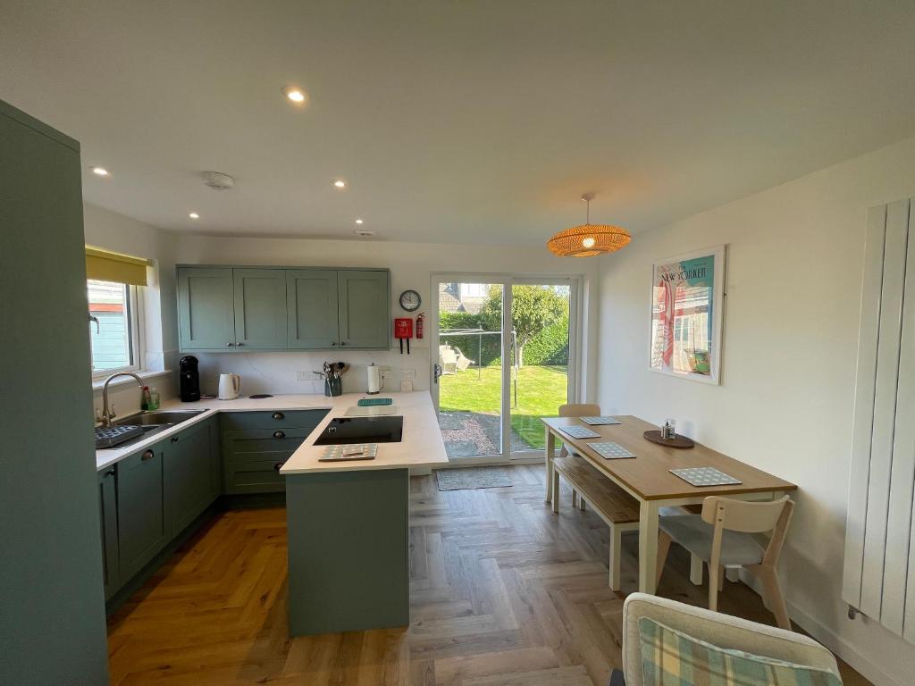 een keuken met groene kasten en een houten tafel bij Nº Twenty Spottiswoode in St Andrews