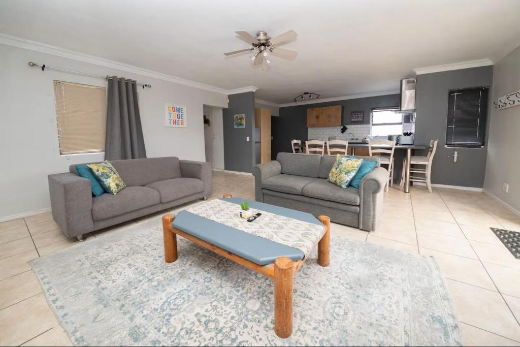 a living room with two couches and a table at 8 Vineyard in Somerset West