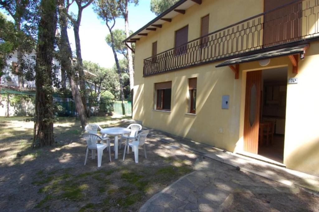 a patio with a table and chairs next to a building at Cozy flat in Rosolina in Rosolina Mare