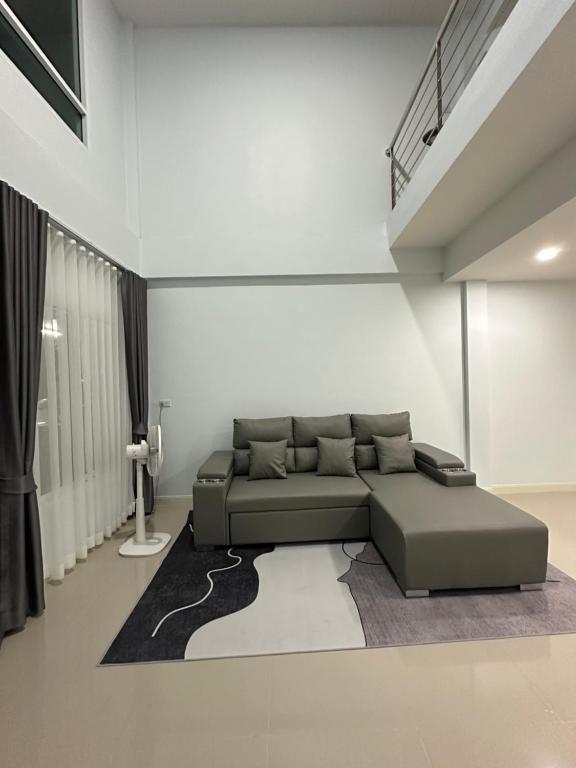 a living room with a couch and a rug at Monday Guesthouse2 Hatyai in Hat Yai