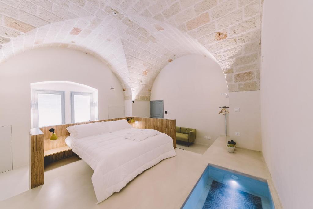 1 dormitorio con 1 cama grande y piscina en Cinquevite, en Polignano a Mare
