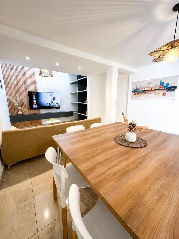 a dining room with a wooden table and a couch at Casa espectacular con 3 habitaciones en suite de lujo, 4 baños, patio al aire libre con jacuzzi y ubicacion perfecta a 3 cuadras de la plaza - Bonavista Rentals in Salta