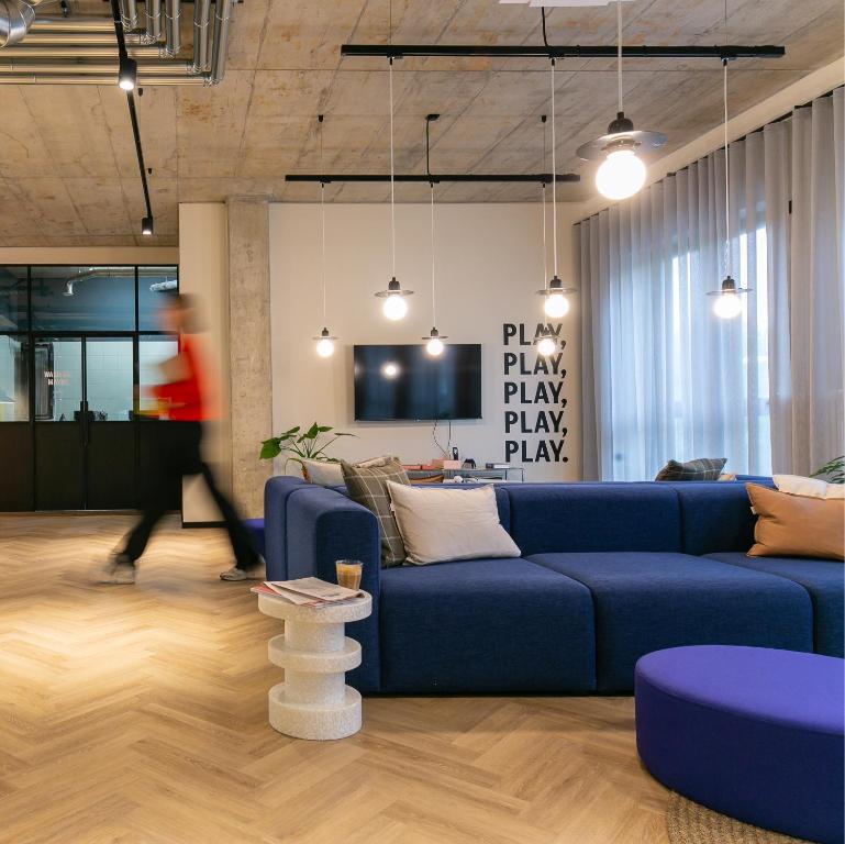 ボーフムにあるSTAYERY Bochum Ehrenfeldの青いソファとテレビのあるリビングルーム