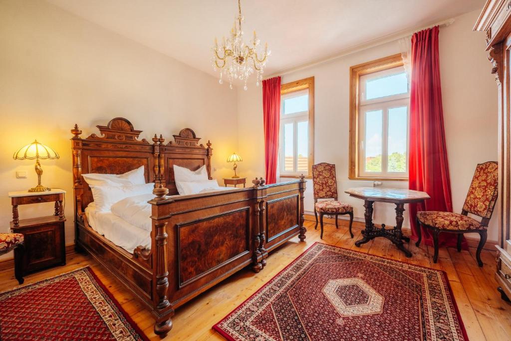 a bedroom with a large wooden bed and a table at Unik Villa- Luxus Appartemente im Oberharz in Sankt Andreasberg