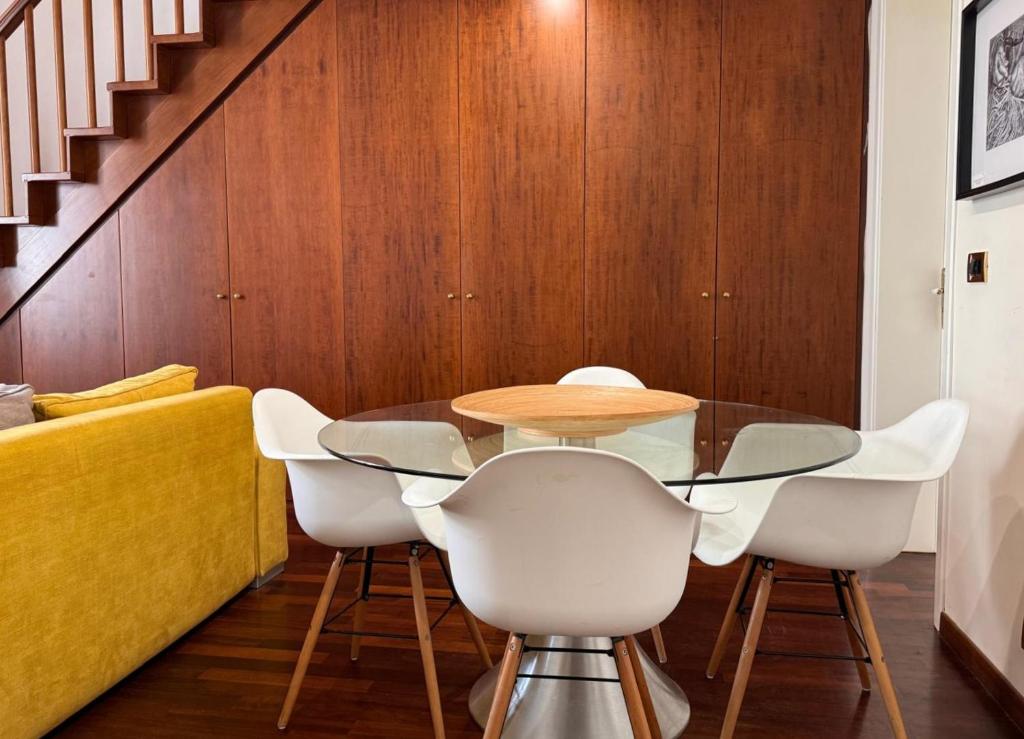 a dining room with a glass table and white chairs at queen 24 in Taranto