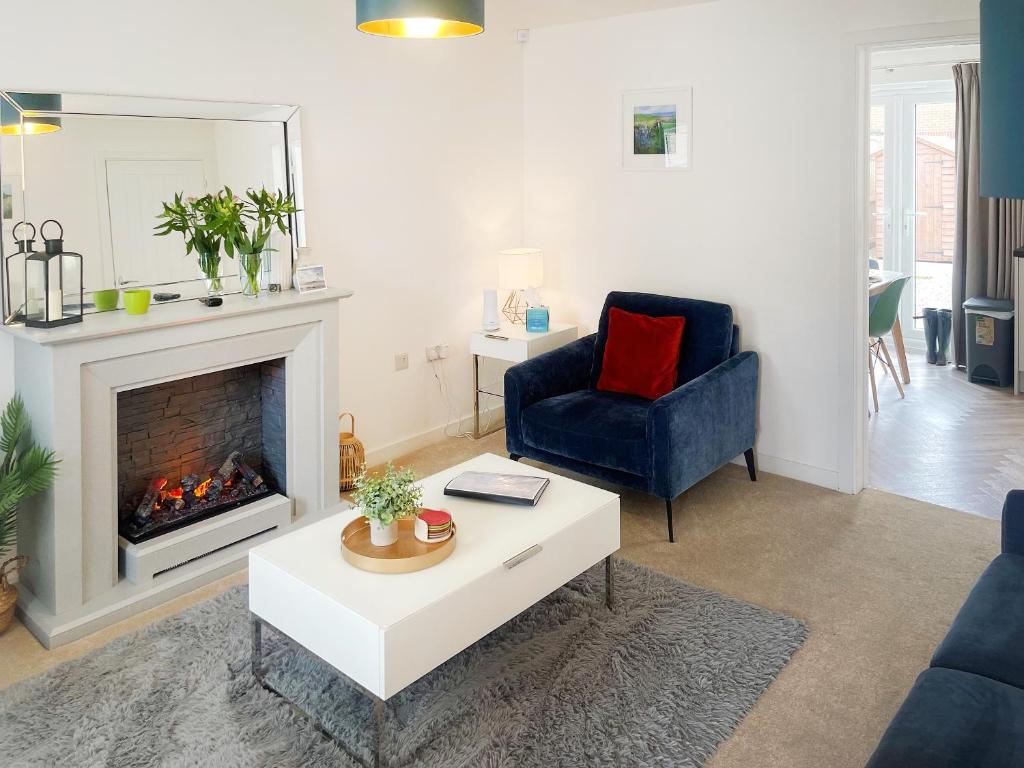 ein Wohnzimmer mit einem Kamin und einem blauen Stuhl in der Unterkunft Pelican Rest - Uk41429 in Amble