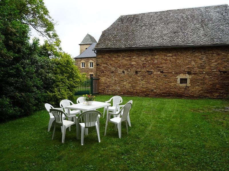 a table and chairs in a yard with a building at Gîte à Luc in Mandailles