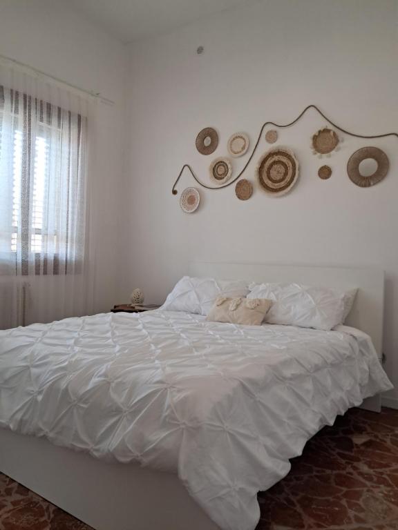 1 dormitorio con 1 cama blanca con cabecero en Prisciò, en Melendugno