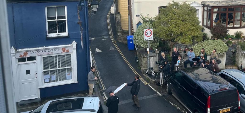 a group of people standing outside of a blue building at As Used On BBC1s BEYOND PARADISE - Prospect House is TWO PRIVATE APARTMENTS in this 17th CENTURY COTTAGE - Apartment 2 has a KIDS CABIN BUNK ROOM - Book both apartments for ONE LARGE HOUSE with Connecting Door In Lobby - PUBLIC PARKING OUTSIDE in Looe