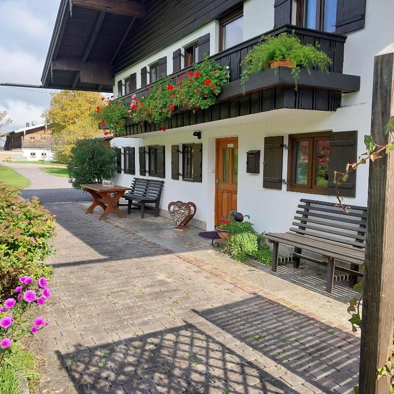 a building with two benches in front of it at Ferienwohnung Beim Straßer in Flintsbach