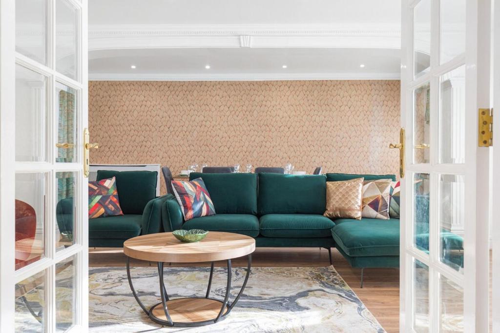 a living room with a green couch and a table at Garden Parking WiFi Near Sky Elstree Studios in Elstree