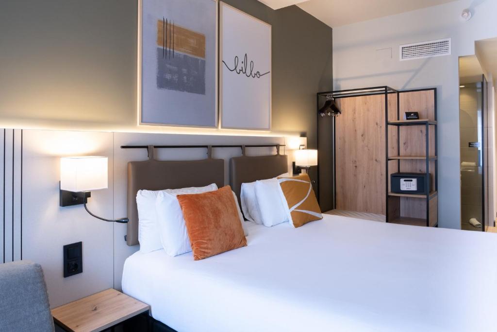 a bedroom with a large bed with white pillows at voco Bilbao - City by IHG in Bilbao