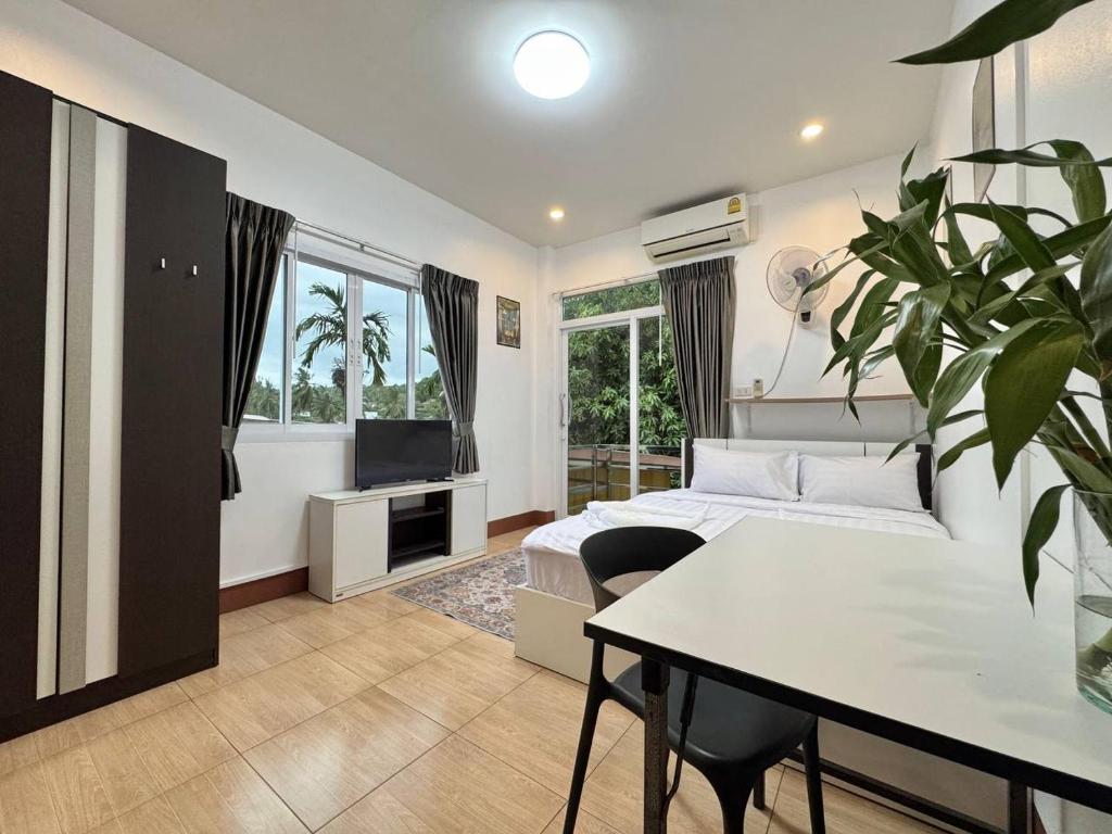 a bedroom with a bed and a table and a tv at PRO Guest House in Thong Sala